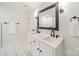 Bright bathroom with black hardware, white cabinets with dual sinks, tiled floors, a mirror, and a towel rack at 1121 S Wendover Rd, Charlotte, NC 28211
