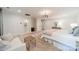 Bedroom with white sofa and woven stool, a chandelier, a neutral bed, and an attached bathroom at 1121 S Wendover Rd, Charlotte, NC 28211