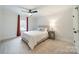 Neutral bedroom features a ceiling fan, a bedside lamp on a wooden nightstand, and a bed with white and gray bedding at 1121 S Wendover Rd, Charlotte, NC 28211