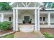 Inviting covered front porch with brick flooring, white columns, and a stylish front door at 1121 S Wendover Rd, Charlotte, NC 28211
