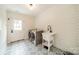 Well-lit laundry room with stylish patterned floor tiles, white cabinets, and modern washer and dryer at 1121 S Wendover Rd, Charlotte, NC 28211