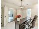 The office features a modern light fixture, a black wooden desk and chair; the laundry room is visible through the doorway at 1121 S Wendover Rd, Charlotte, NC 28211