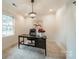 This home office boasts a modern light fixture, neutral walls and black wooden desk with a black leather chair at 1121 S Wendover Rd, Charlotte, NC 28211