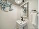 Compact powder room featuring a pedestal sink, decorative mirror, and stylish fixtures at 1121 S Wendover Rd, Charlotte, NC 28211