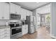 Modern kitchen featuring stainless steel appliances, white cabinets, and granite countertops, leading into a breakfast nook at 1155 Rudder Cir, Salisbury, NC 28146