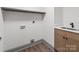 Well lit laundry room featuring wood look flooring, stainless steel sink, and modern design at 120 Pinewood Ln, Rock Hill, SC 29730