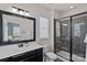 Bathroom with vanity, framed mirror, and tile shower enclosure adjacent to an open doorway at 12214 Bonny Oaks Dr, Cornelius, NC 28031