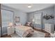Bright bedroom with wood floors, large windows, and sunny decor provides a cheery and inviting space at 12214 Bonny Oaks Dr, Cornelius, NC 28031