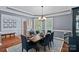 Elegant dining room with wainscoting, a modern chandelier, and a window for natural light, perfect for entertaining at 12214 Bonny Oaks Dr, Cornelius, NC 28031