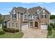 Beautiful two-story home featuring stone accents, neutral siding, a two-car garage, and a well-manicured lawn at 12214 Bonny Oaks Dr, Cornelius, NC 28031