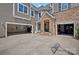 Spacious three car garage with stone and siding exterior, offers ample parking and curb appeal at 12214 Bonny Oaks Dr, Cornelius, NC 28031