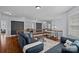 Open concept living area with hardwood floors, cozy sofas, and plenty of natural light from large windows at 12214 Bonny Oaks Dr, Cornelius, NC 28031