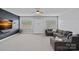 Cozy living room with a sectional sofa, TV, and large windows for comfortable relaxation at 12214 Bonny Oaks Dr, Cornelius, NC 28031