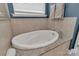 Luxurious soaking tub surrounded by elegant tile and granite countertops at 1230 Therns Ferry Dr, Fort Mill, SC 29708