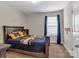 Bedroom with a blue and yellow decor, large window and dark wood furniture at 1230 Therns Ferry Dr, Fort Mill, SC 29708