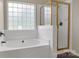 Close up of tub and shower with gold-trimmed glass door, showerhead and glass block window at 12303 Shadow Ridge Ln, Charlotte, NC 28273