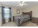 Comfortable bedroom with wooden bed frame, ceiling fan, and natural light from the window with dark curtains at 12303 Shadow Ridge Ln, Charlotte, NC 28273
