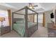 Spacious bedroom with a four-poster bed, tray ceiling, ceiling fan, and natural lighting at 12303 Shadow Ridge Ln, Charlotte, NC 28273