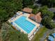 Aerial view of a community pool featuring lounge chairs, umbrellas, and a clubhouse surrounded by lush trees at 12303 Shadow Ridge Ln, Charlotte, NC 28273