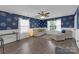Cozy living room featuring hardwood floors, lots of natural light, and blue accent walls at 12303 Shadow Ridge Ln, Charlotte, NC 28273