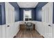 Office area with desk, monitors, and chair, enclosed by white paneled doors and blue walls at 12303 Shadow Ridge Ln, Charlotte, NC 28273