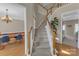 A foyer staircase showcasing wood railing, carpeted steps, and white trim and access to rooms at 12303 Shadow Ridge Ln, Charlotte, NC 28273