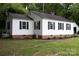 Side view of a single-story home with white siding, black shutters, brick foundation, and green lawn at 1250 Hampton Grace Ave, Lancaster, SC 29720