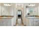 Bathroom featuring dual sinks with granite countertops, tile flooring, and an open bedroom view at 141 Tall Fern Loop, Mooresville, NC 28117