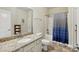 Bright bathroom with a granite vanity top, neutral paint, and a blue patterned shower curtain at 141 Tall Fern Loop, Mooresville, NC 28117