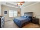 Comfortable bedroom featuring a ceiling fan, tray ceiling, and neutral paint colors at 141 Tall Fern Loop, Mooresville, NC 28117