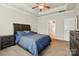 This bedroom features carpet, a dark wooden bedframe, and a ceiling fan at 141 Tall Fern Loop, Mooresville, NC 28117