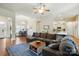 Spacious living room features a ceiling fan, hardwood floors, and a blue patterned area rug at 141 Tall Fern Loop, Mooresville, NC 28117
