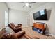 A living room featuring leather furniture, a ceiling fan, and a mounted television at 141 Tall Fern Loop, Mooresville, NC 28117