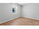 Bright bedroom features wood-look flooring, neutral walls, and natural light from a large window at 146 Georgia Sw St, Concord, NC 28025