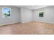 Bright bedroom features wood-look floors, neutral walls, and two windows allowing natural light at 146 Georgia Sw St, Concord, NC 28025