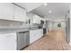 Well-lit kitchen with stainless steel appliances, granite countertops, and white cabinets at 146 Georgia Sw St, Concord, NC 28025