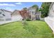The backyard is lush and green, enclosed by a white picket fence with a small tree at 14923 Almondell Dr, Huntersville, NC 28078