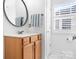 Bright bathroom features a wood vanity with a stylish round mirror and modern fixtures at 14923 Almondell Dr, Huntersville, NC 28078