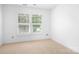 Empty bedroom with neutral carpet and large windows, ready for your personal touch at 14923 Almondell Dr, Huntersville, NC 28078