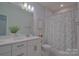 This bathroom features a double vanity and shower-tub combo with floral shower curtain at 15216 Shallow Ridge Rd, Charlotte, NC 28278