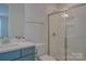 Modern bathroom features a glass-enclosed shower, sleek vanity, and neutral color palette at 15216 Shallow Ridge Rd, Charlotte, NC 28278