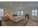Bright bedroom with large windows, neutral decor, tray ceiling and hardwood flooring at 15216 Shallow Ridge Rd, Charlotte, NC 28278