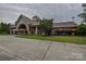 Stately clubhouse featuring elegant entrance, outdoor seating, manicured landscaping and clock tower at 15216 Shallow Ridge Rd, Charlotte, NC 28278