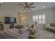 Living room showcasing a ceiling fan, plantation shutters, and a television at 15216 Shallow Ridge Rd, Charlotte, NC 28278