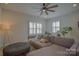 Cozy living room featuring a ceiling fan, plantation shutters, and neutral decor at 15216 Shallow Ridge Rd, Charlotte, NC 28278