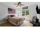 Comfortable bedroom featuring a ceiling fan, mounted TV, and plenty of natural light at 18745 Bluff Point Rd, Cornelius, NC 28031