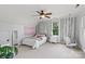 Bright bedroom featuring a ceiling fan, boho wall decor, and egg chair near the window at 18745 Bluff Point Rd, Cornelius, NC 28031