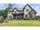 Beautiful two-story home with a manicured lawn, stone accents, and decorative shutters at 18745 Bluff Point Rd, Cornelius, NC 28031