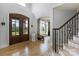 Inviting foyer with hardwood floors, a decorative wooden front door, and a staircase with wrought iron railings at 18745 Bluff Point Rd, Cornelius, NC 28031