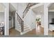 Elegant foyer with hardwood floors, staircase with wrought iron railings, and views into the dining room at 18745 Bluff Point Rd, Cornelius, NC 28031